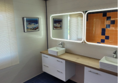 Salle de bain moderne avec deux lavabos et un grand miroir au-dessus.